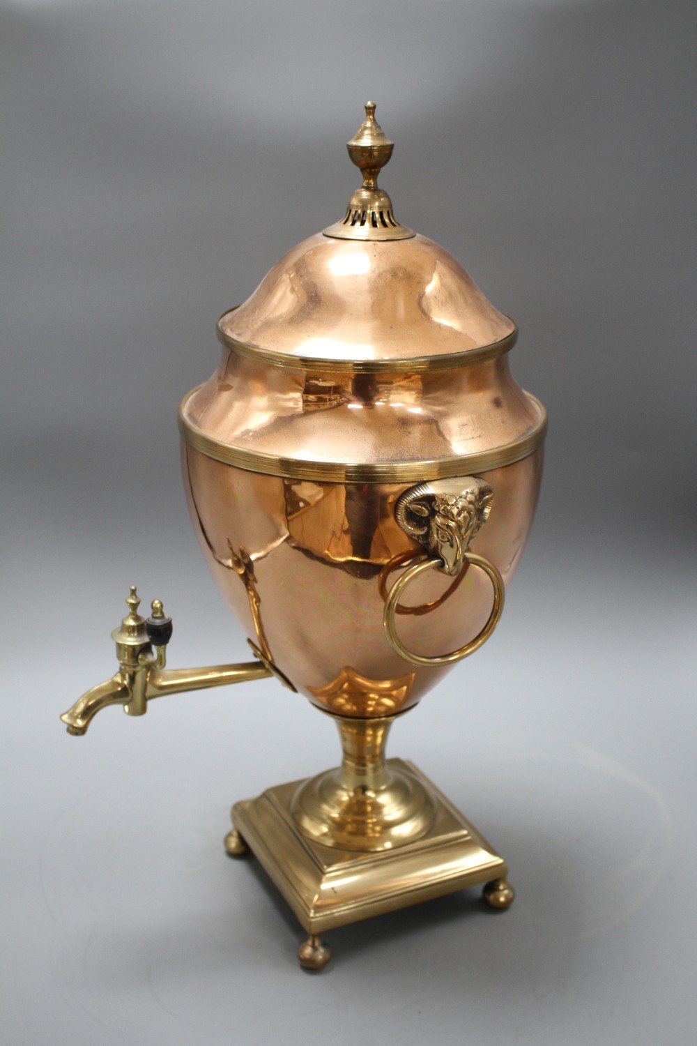 A Regency brass mounted copper tea urn, with rams mask ring handles, height 51cm